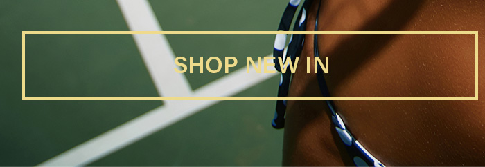 Person in a blue polka-dot bikini bottom on a green tennis court. Discover new arrivals and latest swimwear fashion. Shop New In!