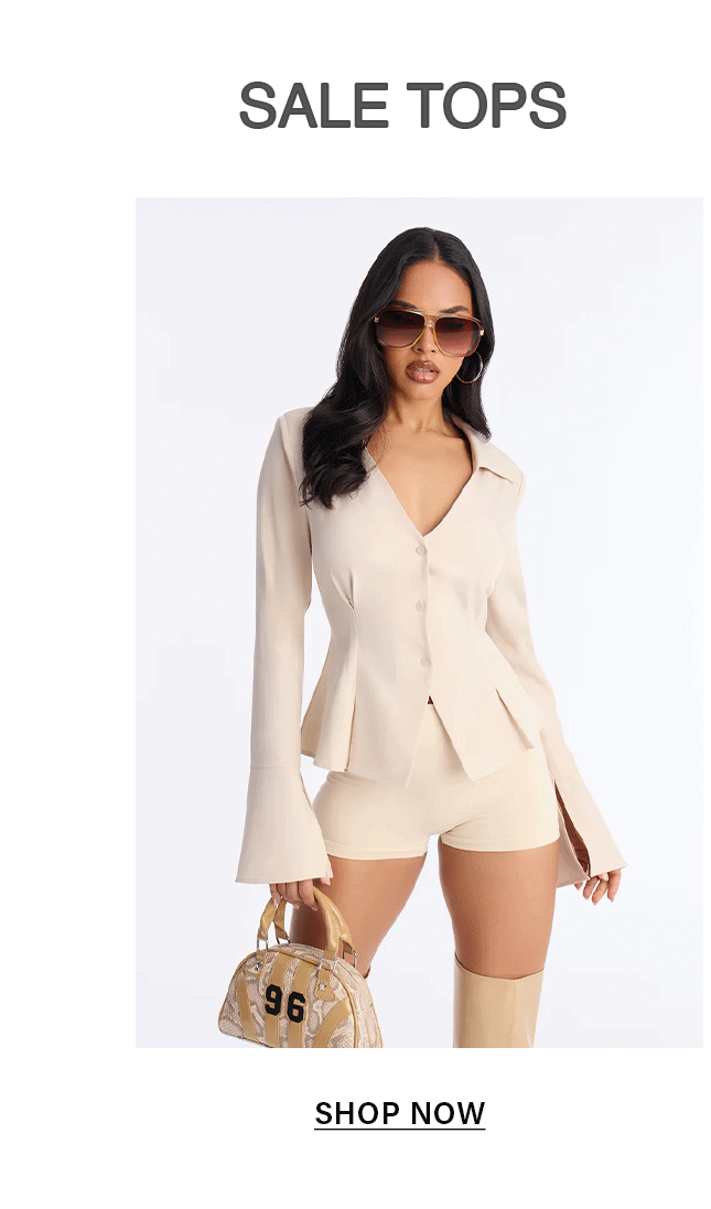 Stylish woman wearing beige V-neck peplum blazer top, matching shorts, sunglasses, and handbag. Promoting fashion sale tops. Shop now.
