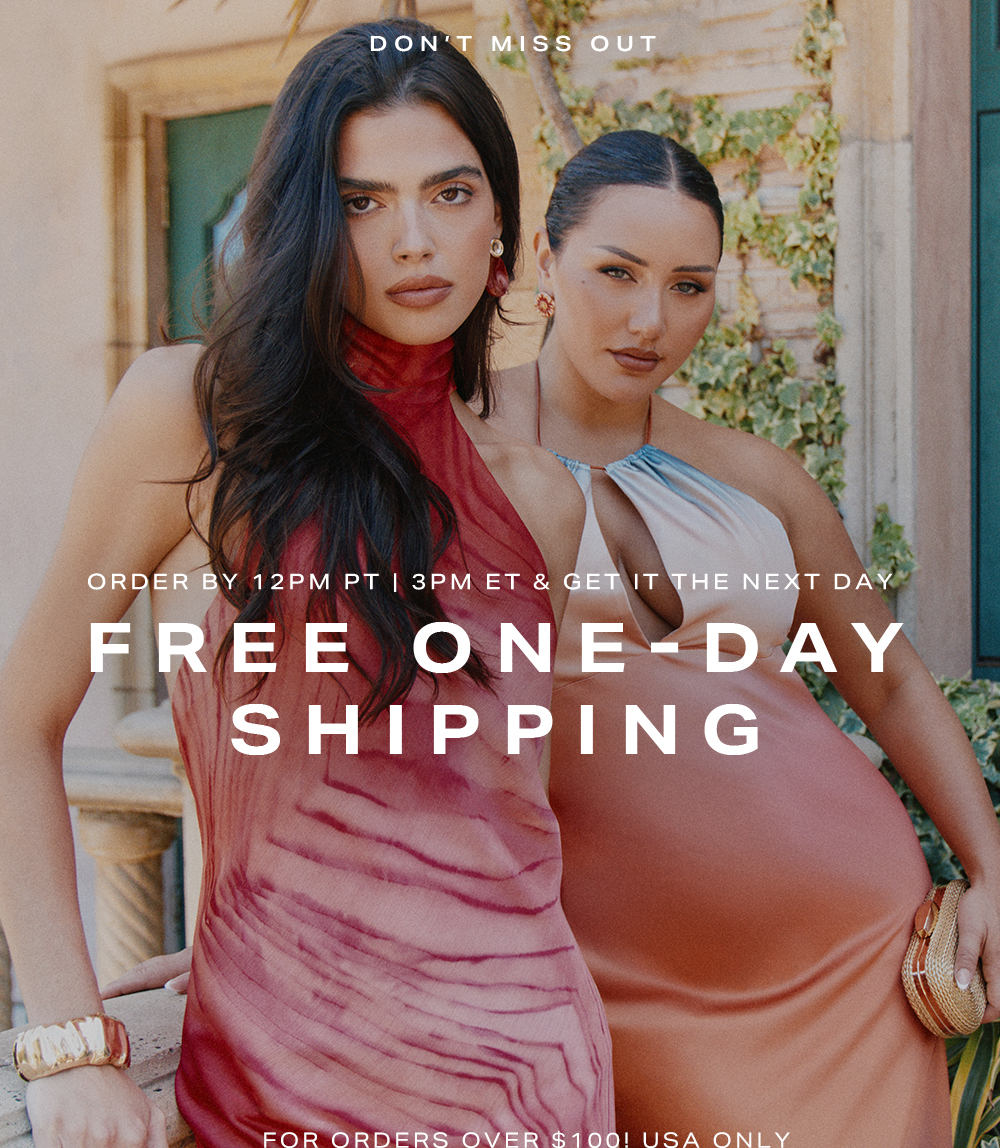 Two women modeling stylish red and peach summer dresses against a stucco wall, promoting free one-day shipping for women's fashion.