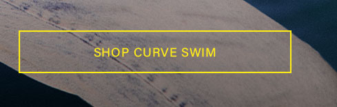 Close-up of a person's leg in textured gray-blue denim, partially submerged in dark water, with yellow 'SHOP SWIM' text. Discover our swim collection.