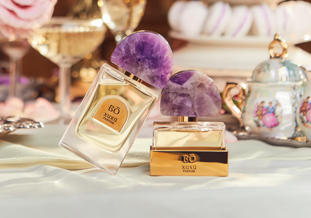 an image of a table with a bottle of perfume and a glass of wine
