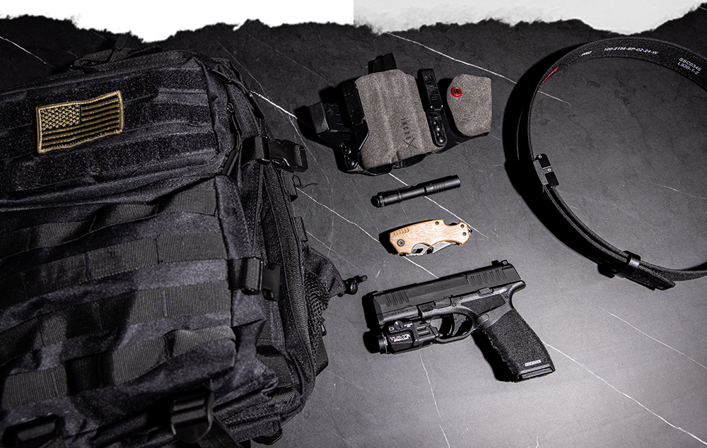 Incog X and a Hellcat Pro on a table with a backpack, flashlight, and EDC belt