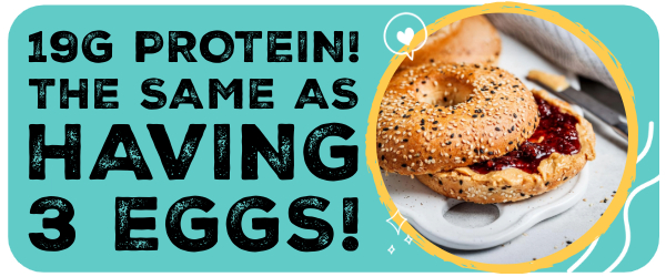A lighlty toasted bagel sitting on a chopping board, slathered with peanut butter and jam