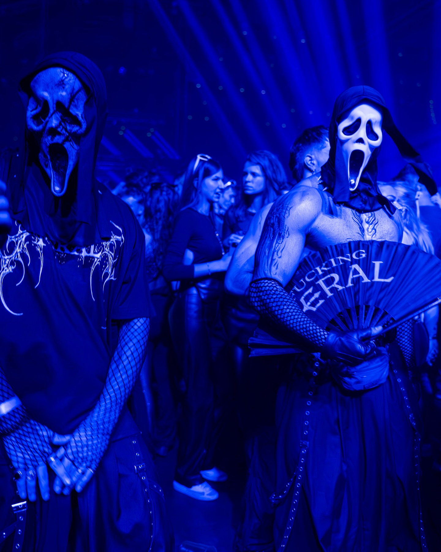 Crowd shot at a hard techno rave — FERAL sigilism gloves in the air, dancefloor scale, 4am energy