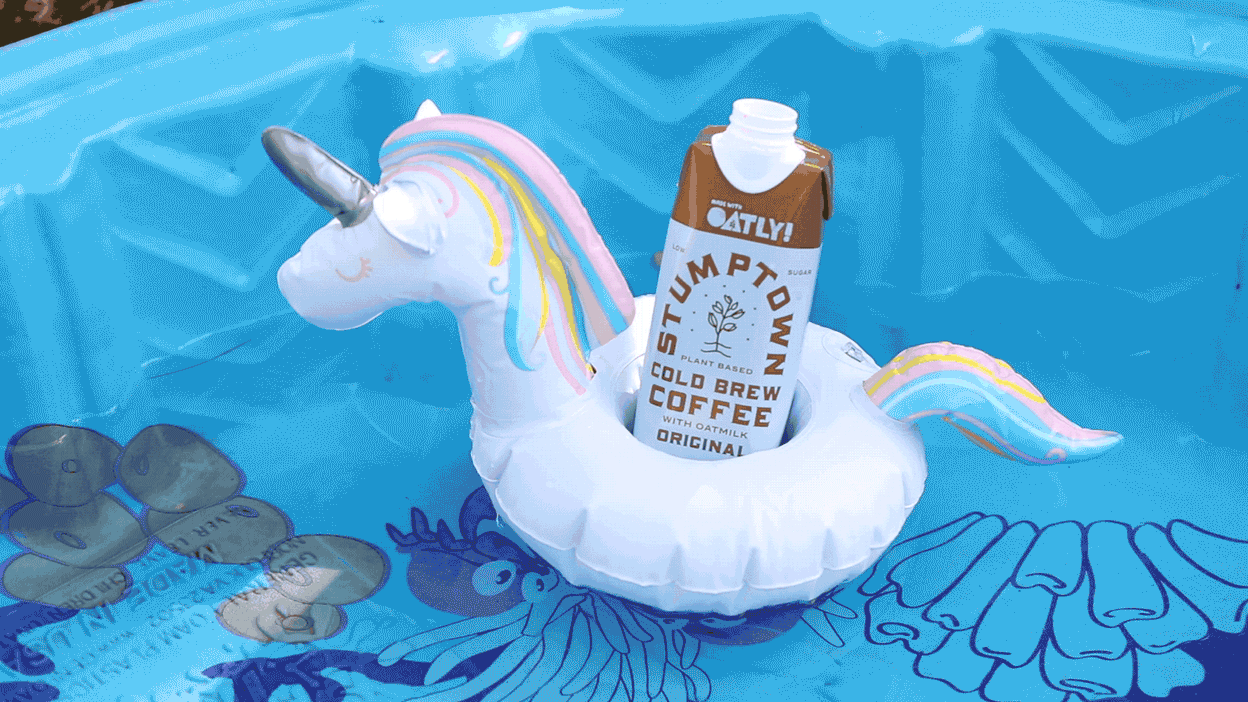 Gif of an Original Stumptown Cold Brew Coffee with Oatly in an inflatable unicorn in a kiddie pool.