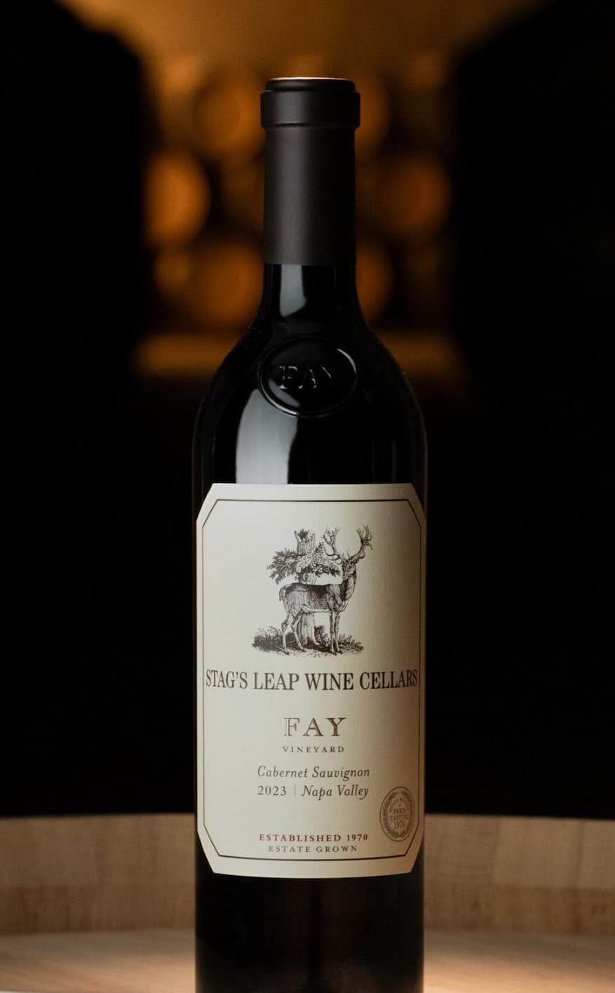 Bottle of 2023 FAY Cabernet Sauvignon on barrel in cave.