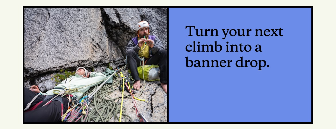 Two climbers on a belay ledge, one lying down and one playing a tin whistle. 