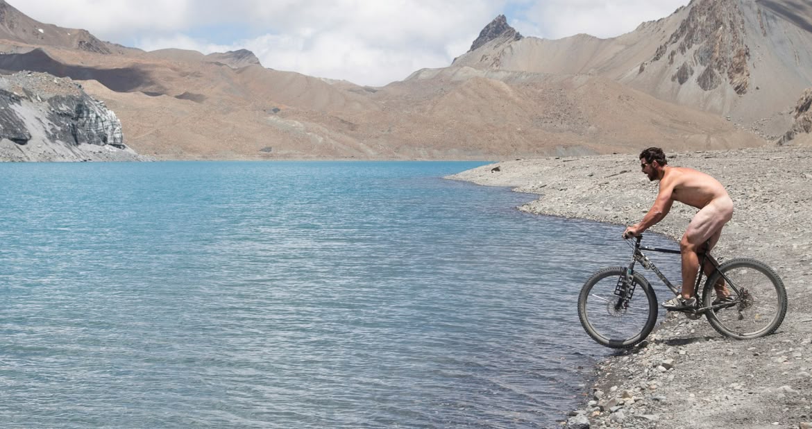 A person rides their bike into a lake. 