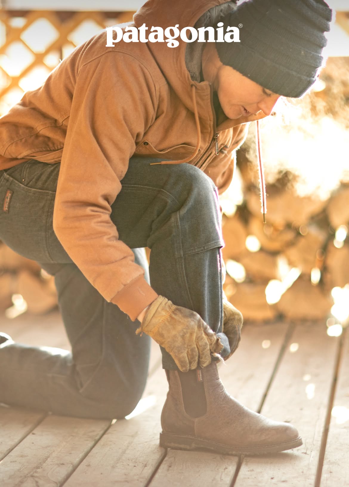 Patagonia. A person kneels on a porch to roll up pant cuffs.