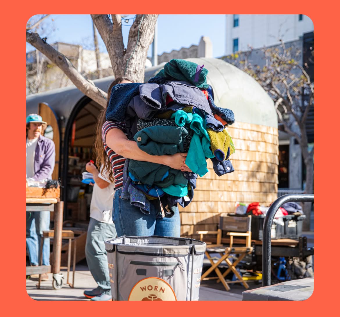  A person holding a pile of clothing. 
