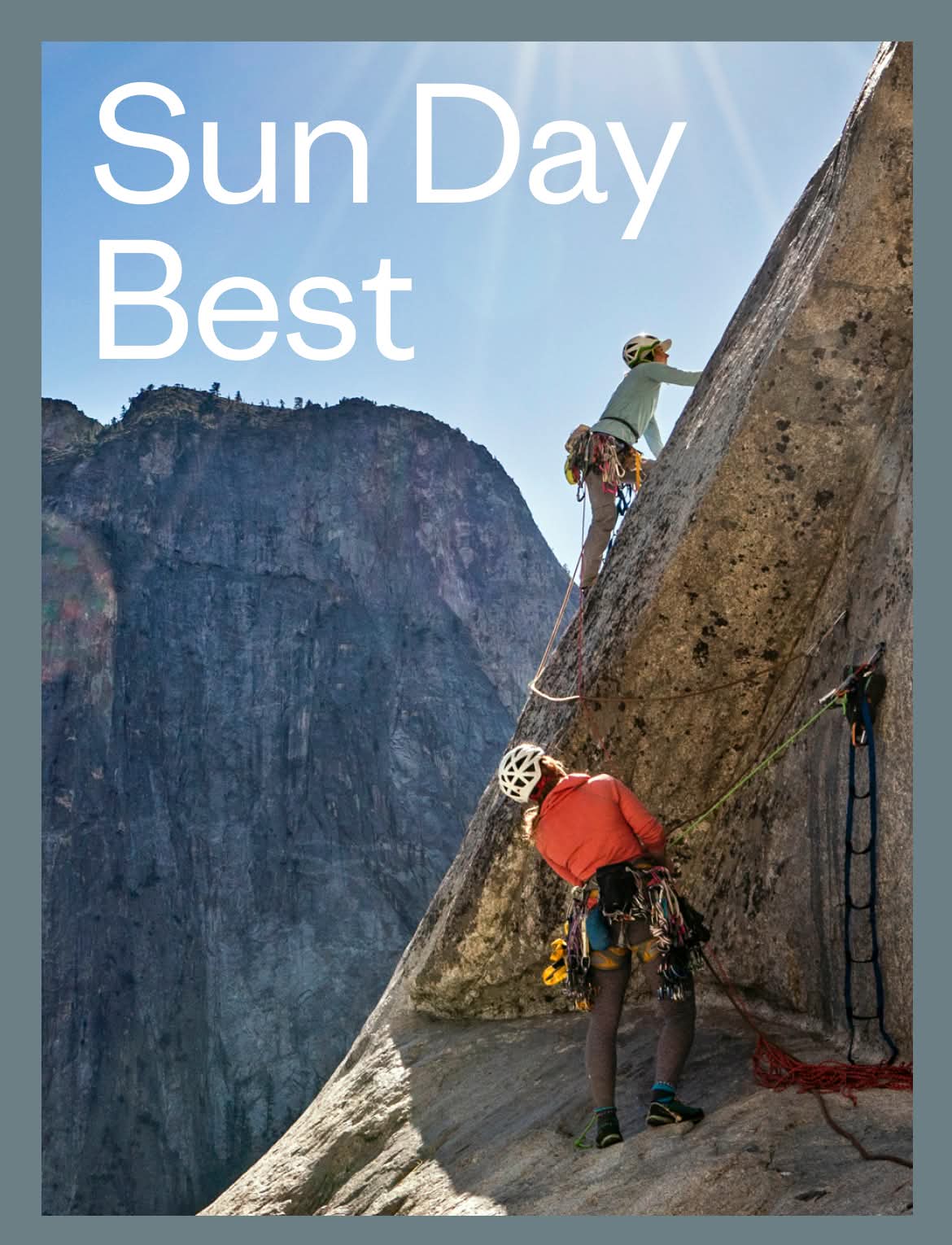 Two people climb a big wall on a sunny day.