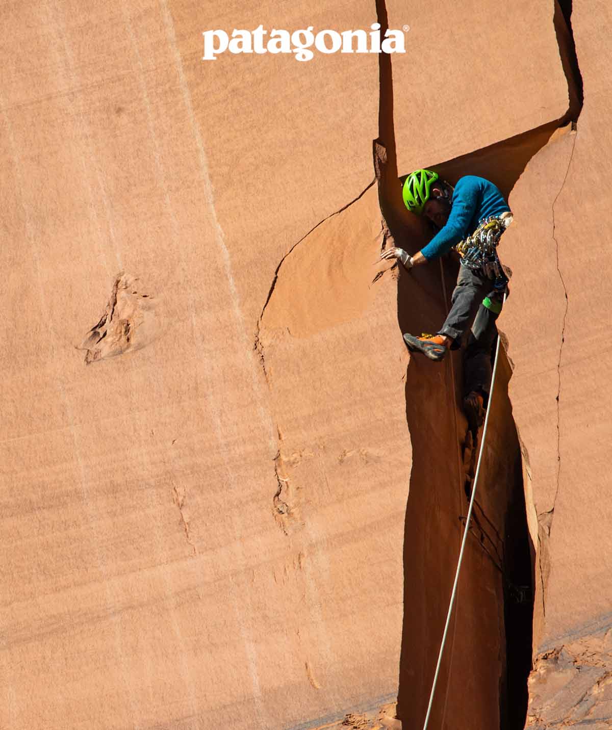 A climber inches their way up a wide offwidth.