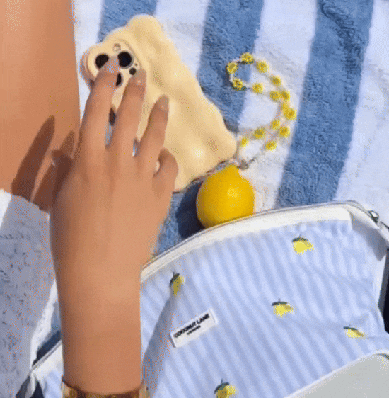 Gif of woman picking up her phone with lemons and pouch