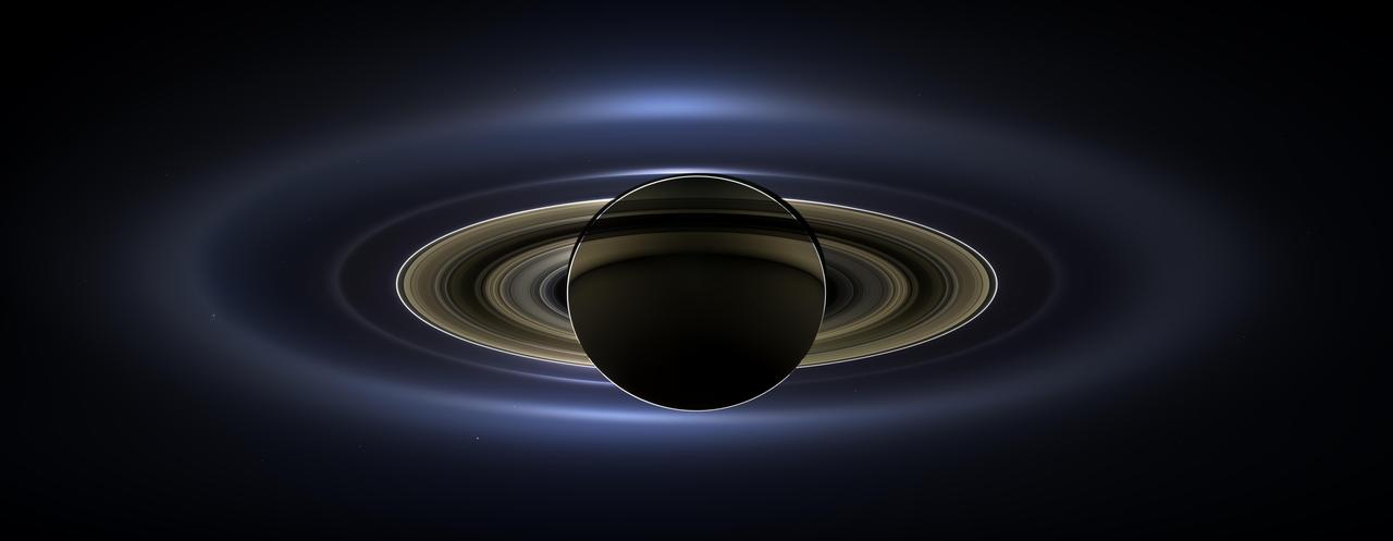 Saturn backlit by the Sun, with Earth a faint dot beneath the rings