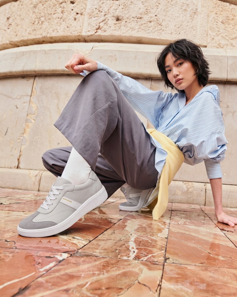 Dream Sport Trainer in Ash Grey, worn on marble steps.