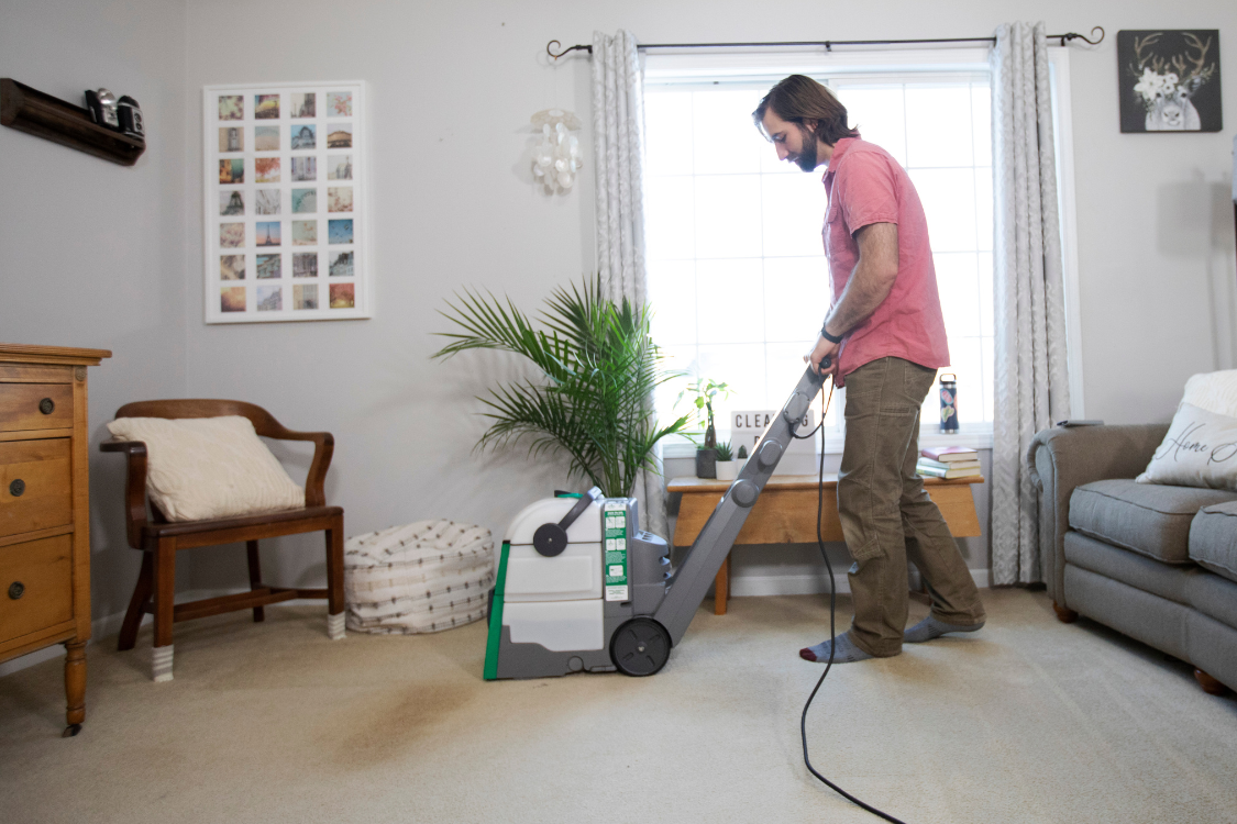 Cleaning carpet with a BISSELL Big Green carpet cleaner rental