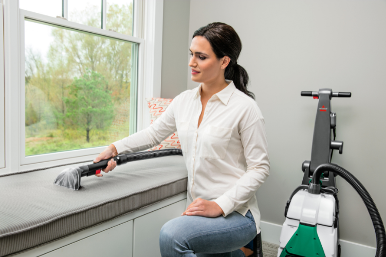 Woman cleaning upholstery with BISSELL Big Green