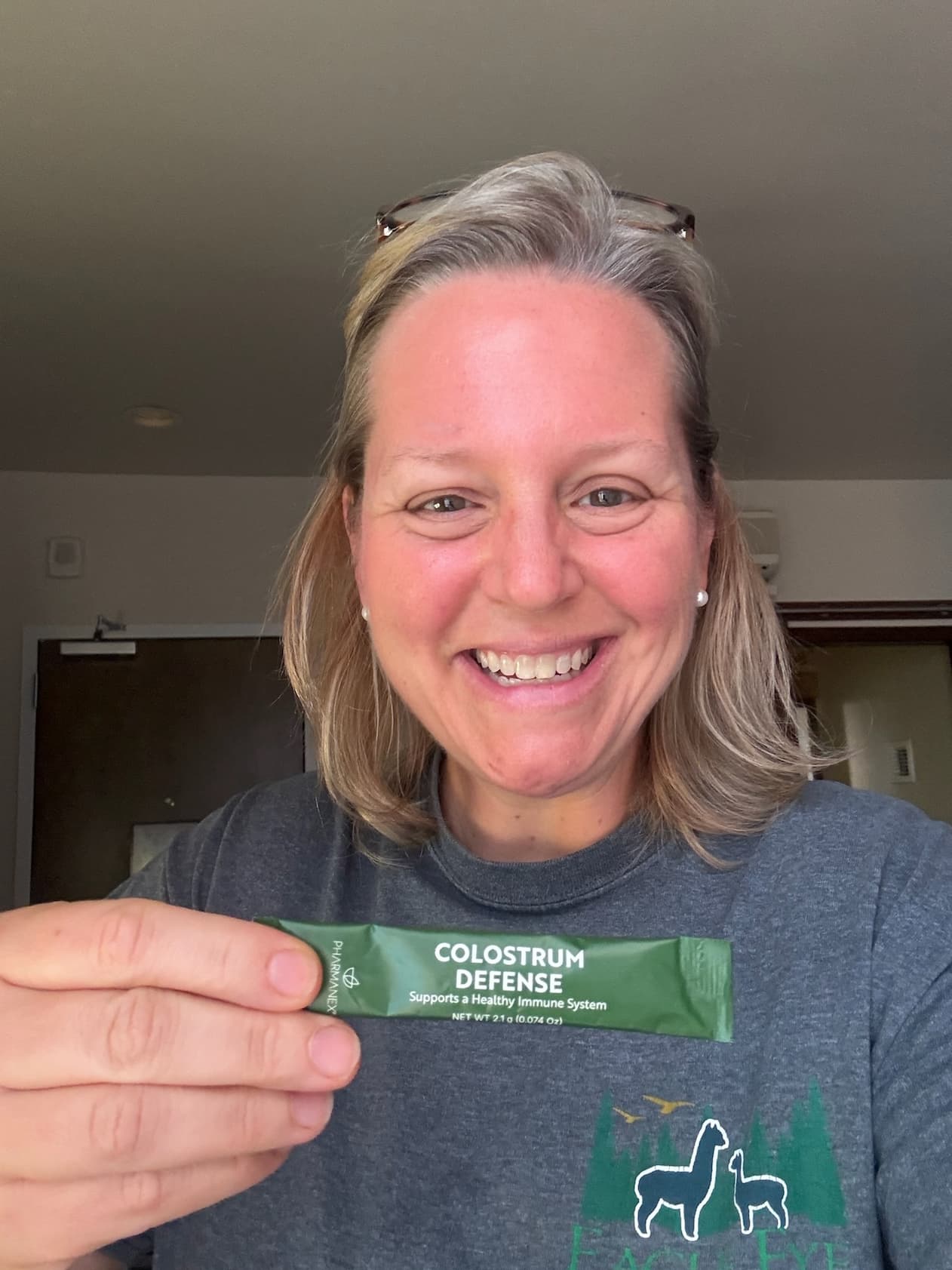 Kerri holding a glass of bovine colostrum supplement at Eagle Eye Farm