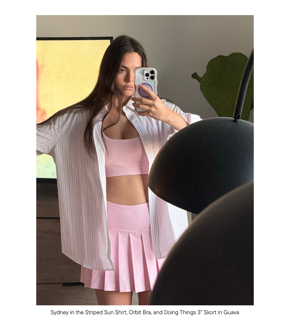 Sydney in the Striped Sun Shirt, Orbit Bra, and Doing Things 3” Skort in Guava  Sydney in the Striped Sun Shirt, Orbit Bra, and Doing Things 3” Skort in Guava