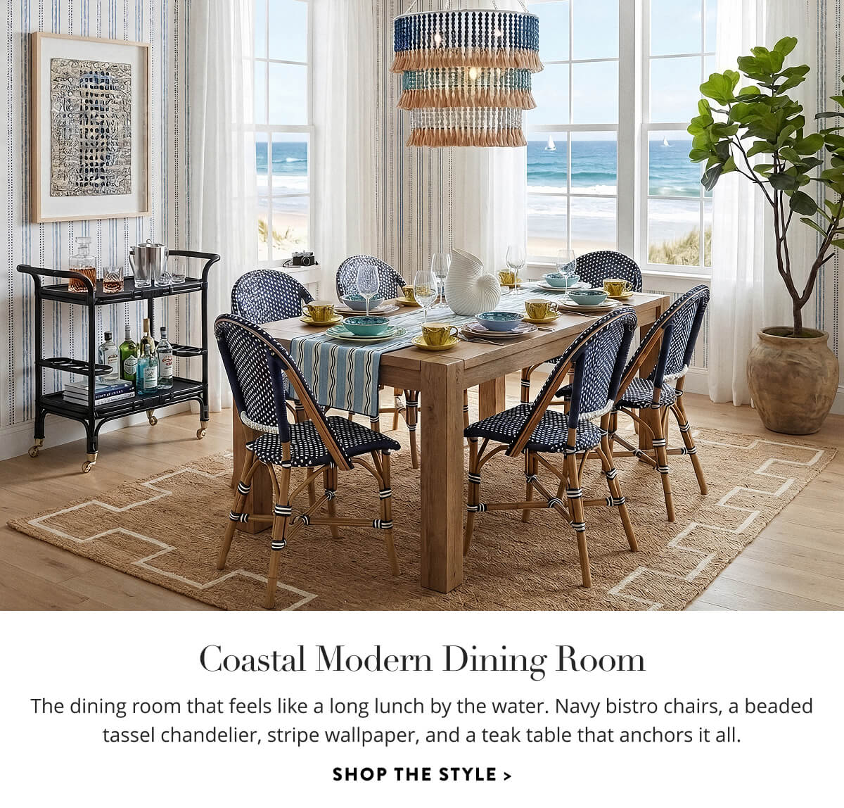 Coastal Modern Dining Room: The dining room that feels like a long lunch by the water. Navy bistro chairs, a beaded tassel chandelier, stripe wallpaper, and a teak table that anchors it all. Shop the style.
