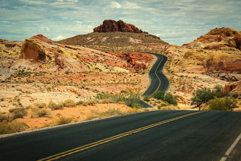 A blacktop road winding through a desert in the american southwest.