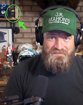 A photo of Ryan Fitzpatrick on a podcast with a Beardbrand bottle in the background.